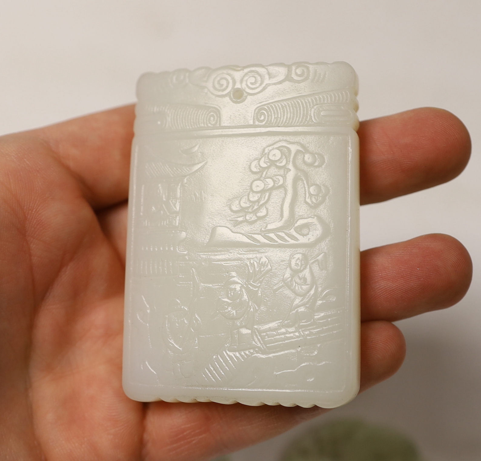 A Chinese white jade pendant plaque and three jadeite pendants, largest 7cm